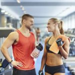 Un hombre y una mujer se sonríen en el gimnasio, instrucciones ligar en el gimnasio (IStock)