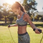 Fit young woman with jump rope in a park
